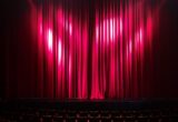 Scène de théâtre avec rideaux rouges et fauteuils vides