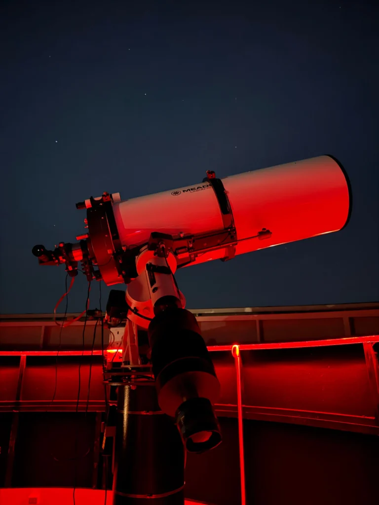 Télescope dans un observatoire éclairé de nuit