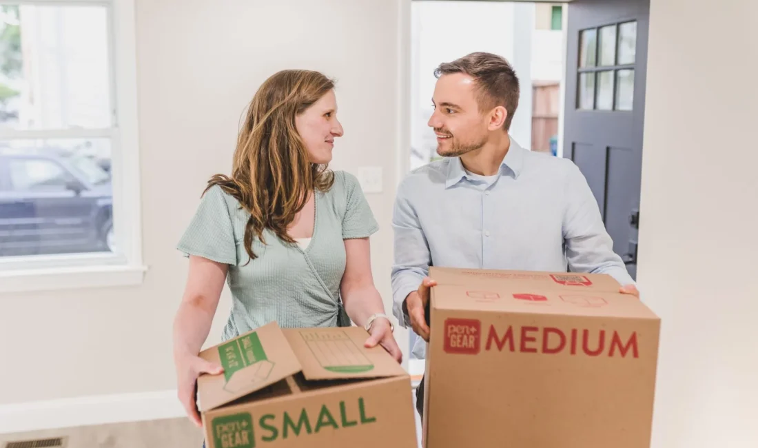 Couple transportant des cartons dans un nouveau logement